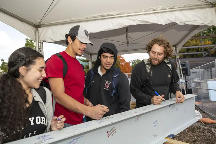 Students sign the final structural beam of the Highmark Center for Health, Wellness and Athletics during its topping-off event.