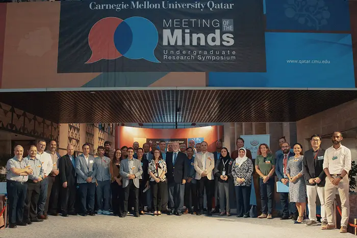 large group of people on stage at Meeting of the Minds in Qatar