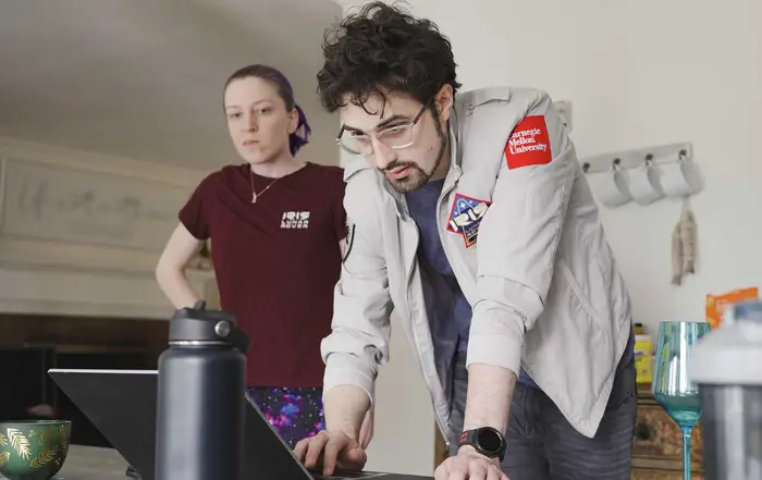 Raewyn Duvall and Connor Columbo work at a computer.