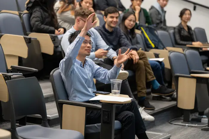 Po-Shen Loh seated in audience with his hand raised