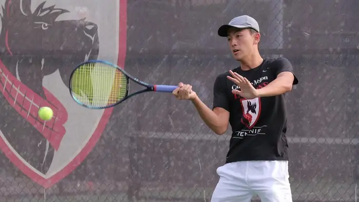 Derek Wong hitting tennis ball with racquet