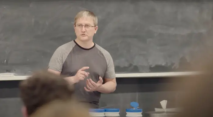 Jeffrey Hinkelman teaching in front of a chalk board