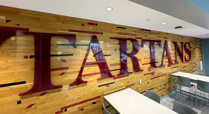 Wooden flooring salvaged from Skibo Gym with the word "Tartans."