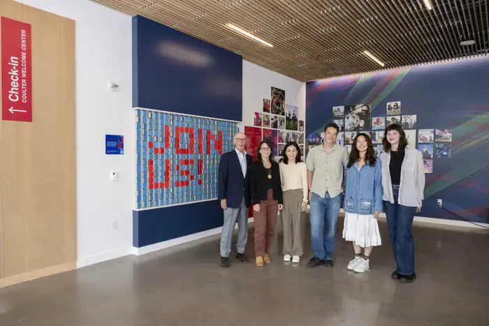 A group of people pose for a photo in the Coulter Welcome Center