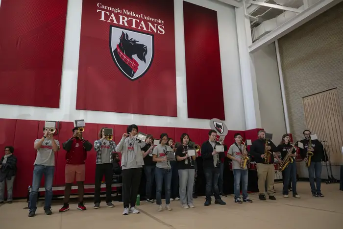 The Kiltie Band plays in a gymnasium.