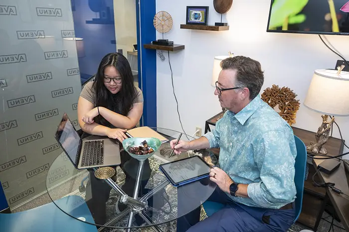 Vionnie Khong and Shawn Fertitta looking at laptop