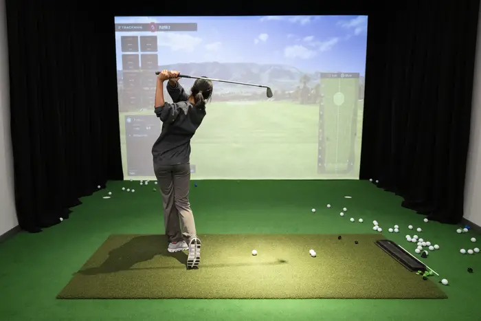 A golfer using an indoor simulator.