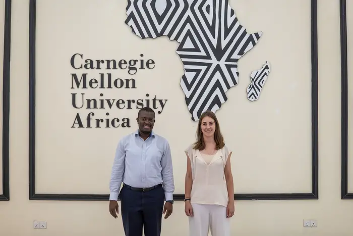 Two people in front of a map of Africa