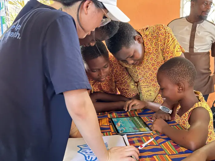 Students in Ghana use a tablet. 