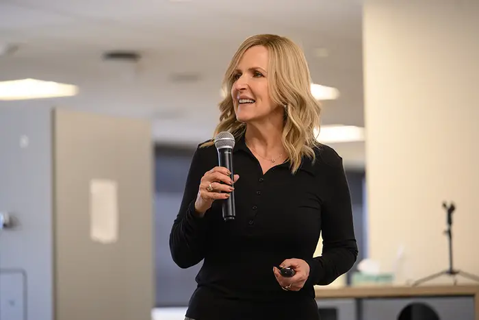 Dena Haritos Tsamitis speaks using a microphone