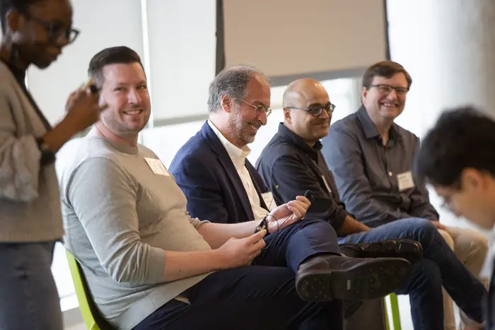 Six people engaged in a lively discussion during a conference