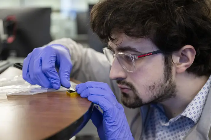 Connor Colombo examines a piece of the payload. 