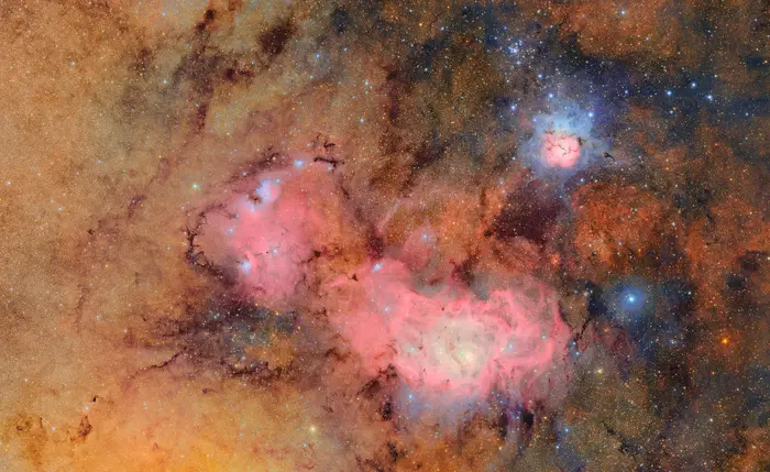 This image combines 678 separate images taken by NSF-DOE Vera C. Rubin Observatory in just over seven hours of observing time. Combining many images in this way clearly reveals otherwise faint or invisible details, such as the clouds of gas and dust that comprise the Trifid nebula (top right) and the Lagoon nebula, which are several thousand light-years away from Earth.