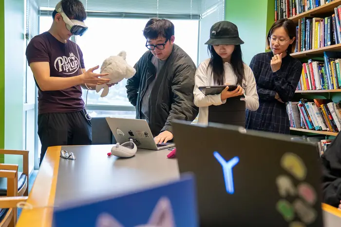 Brian He troubleshoots the Apple Vision Pro in between playtesting sessions with help from Jerry Zheng, Paige Li, and Sophie Huang.