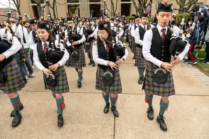 Elizabeth Knox, Alexandra Knox and Roy Huang at the front of the CMU Pipes and Drums band.