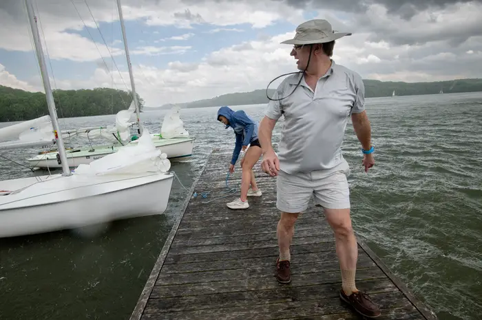 Sandholm and his daughter prepare the sailboat on a dock for launch.