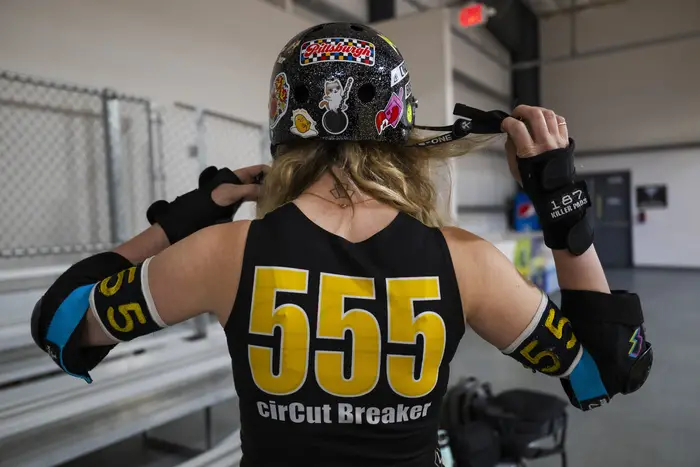 A derby skater wears the number "555." 