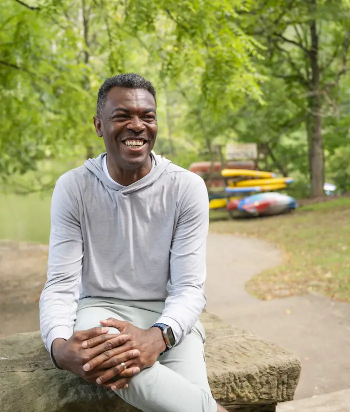 Tagbo Niepa in front of a pile of kayaks.