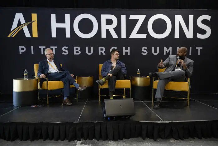 Derek Ham, at right, sits on a panel with two other peoples in front of a wall that reads "AI Horizons Pittsburgh Summit."