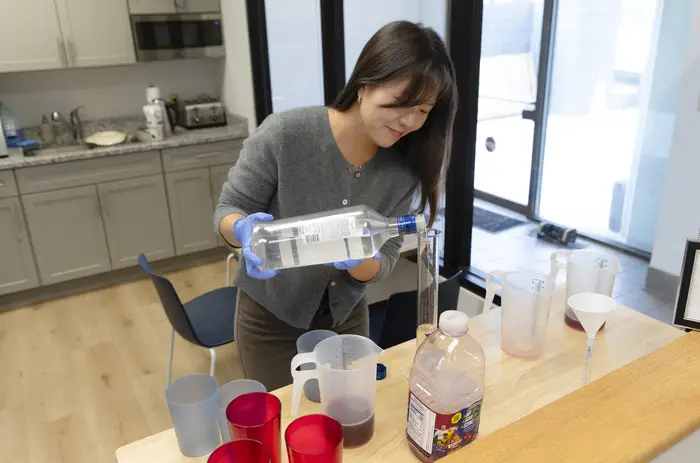 A researcher pours a cocktail.