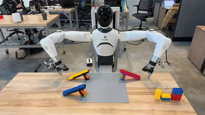 A robot at a table building lego structures. 