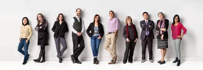 A group of experts standing in front of a wall