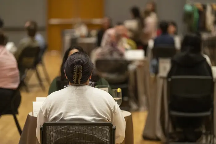 Students sit at tables in pairs for discussion. 