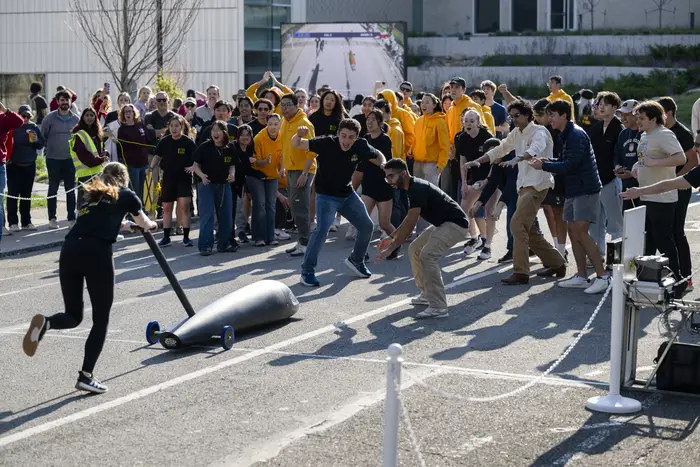 Students push a Buggy across the finish line. 