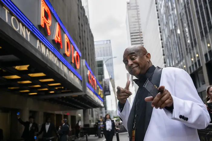 Freddie Hendricks points to camera outside of Radio City Music Hall. 