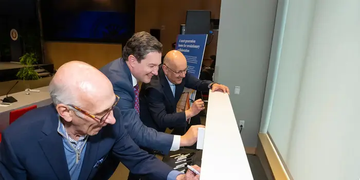 Pictured from left to right: Board of Trustees Chair David A. Coulter (TPR 1971), Director of the Richard King Mellon Foundation Sam Reiman (HNZ 2004) and CMU President Farnam Jahnian sign the final Hall of Sciences beam before its installation.