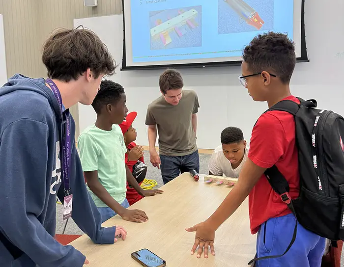 Jacob McCauley with students around a table