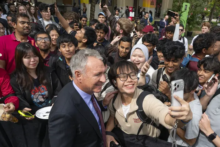 Ken Griffin takes a selfie with a CMU student.