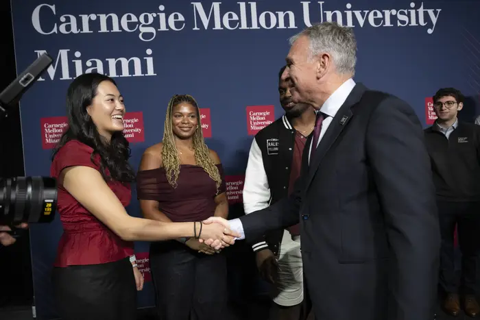 Ken Griffin shakes hands with CMU students.