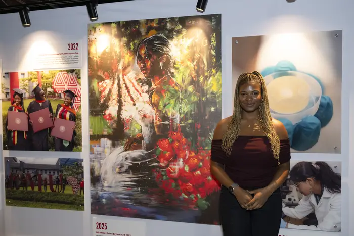 A student poses with her artwork. 