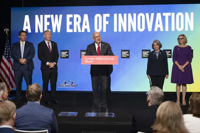 Farnam Jahnian speaks in front of a wall that reads "A NEW ERA OF INNOVATION."