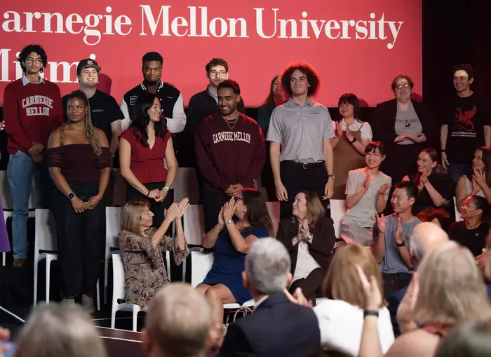 CMU students stand and are recognized at an event. 
