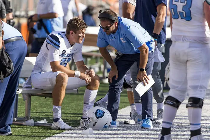 Larsen talks to a player on the sideline