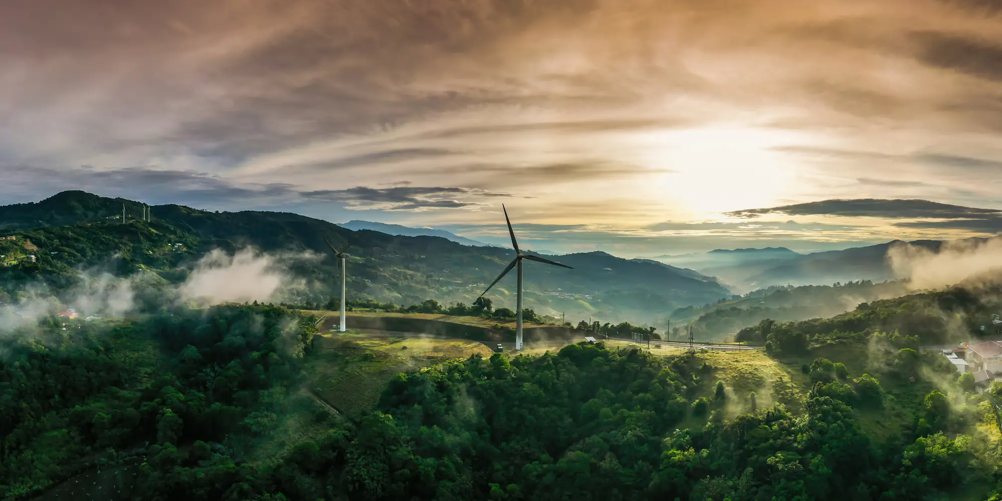 green landscape showing wind turbine with sky in background