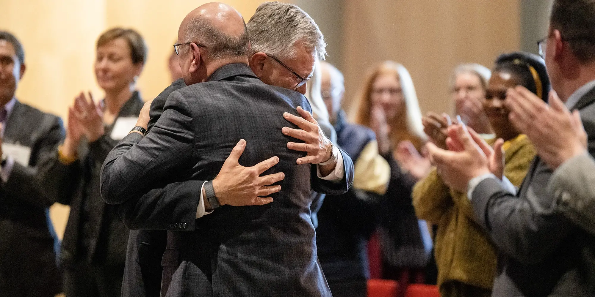 Farnam Jahanian and Mike Steidel hug.