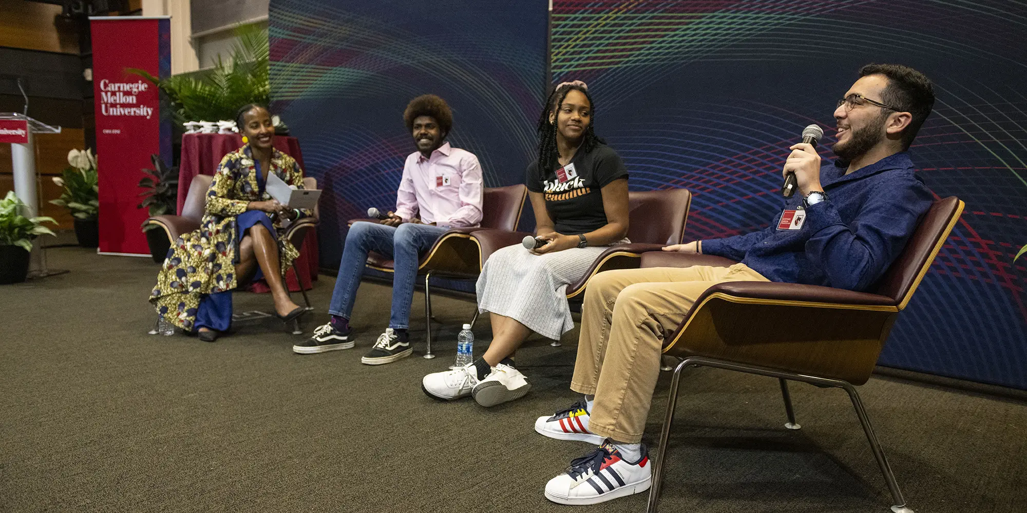 panel discusssion showing four people sitting on a stage 