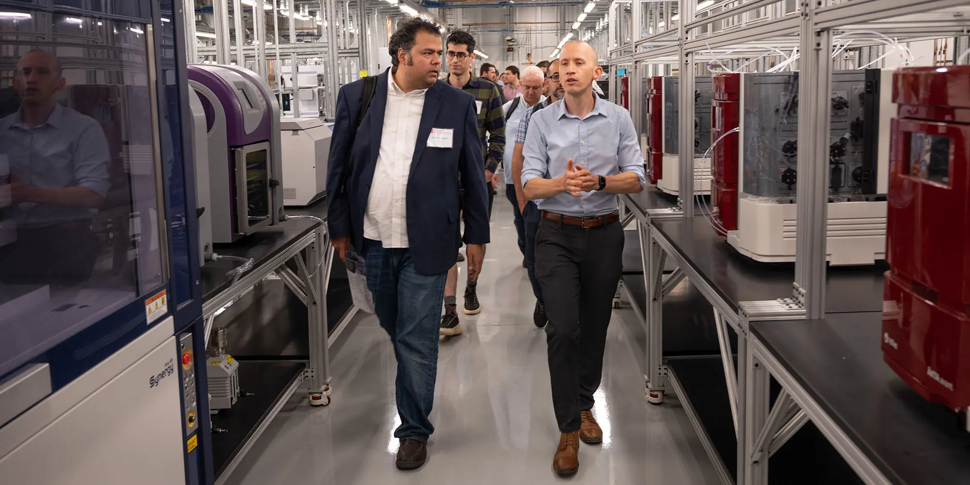 Two people walking between machinery