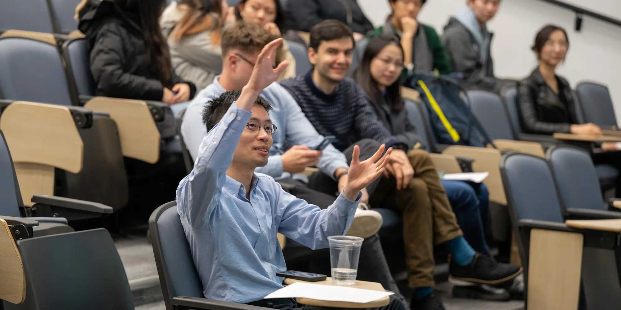 Po-Shen Loh seated in audience with his hand raised