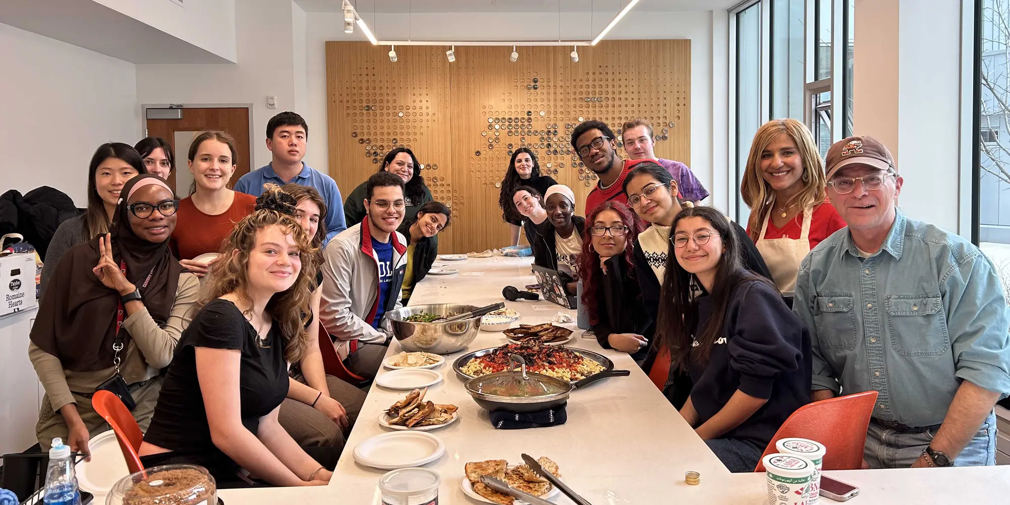 A group photo taken over cultural food prepared for Friendsgiving