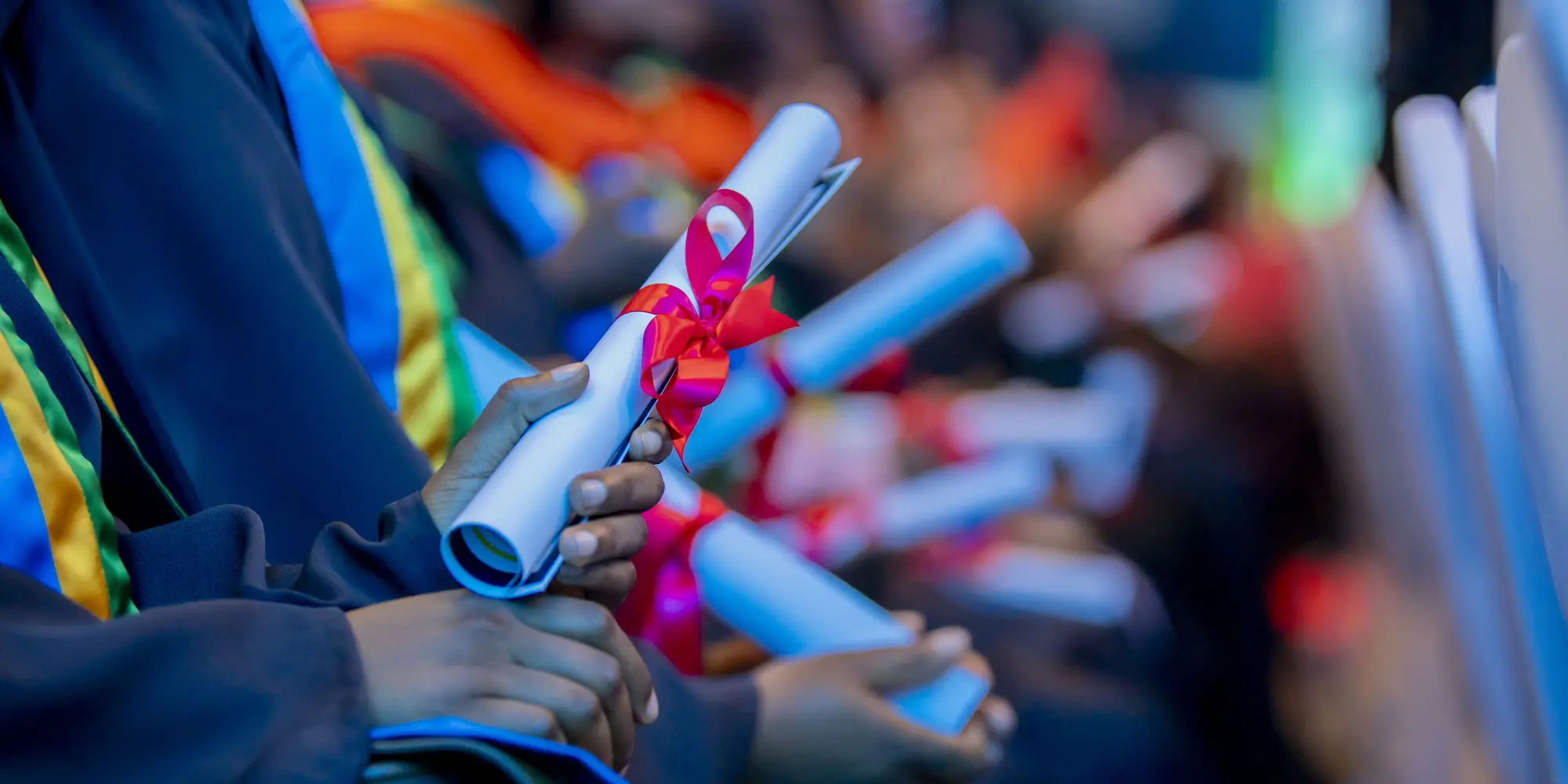 graduates holding dipolomas