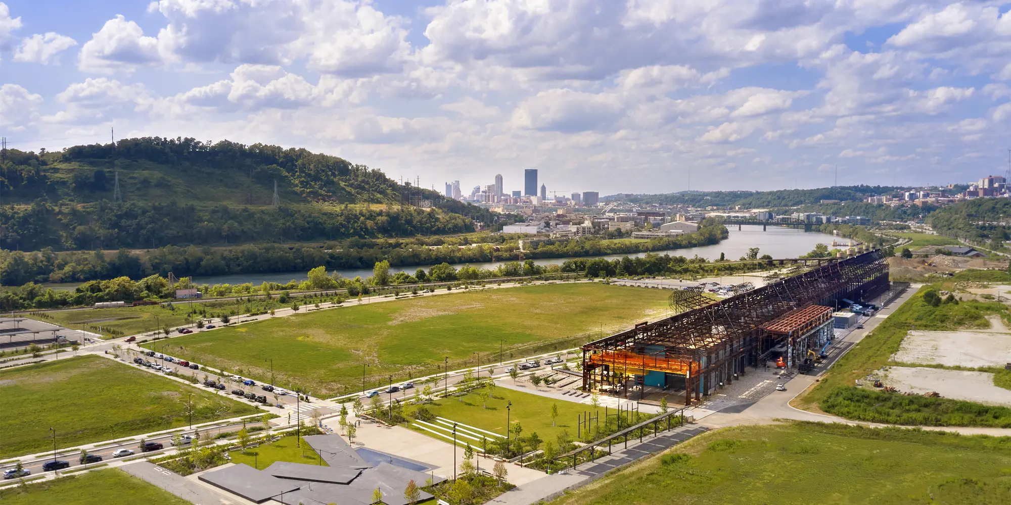 aerial view of Mill 19 in foreground with Pittsburgh, hills and sky in background