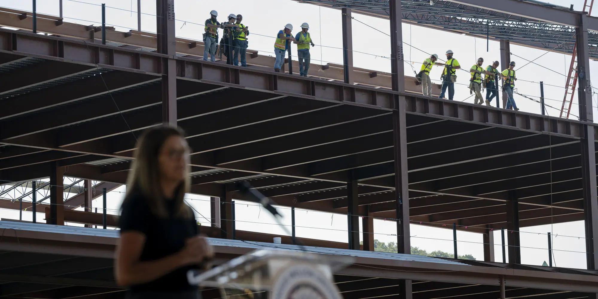 Workers watch the ceremony from the building.