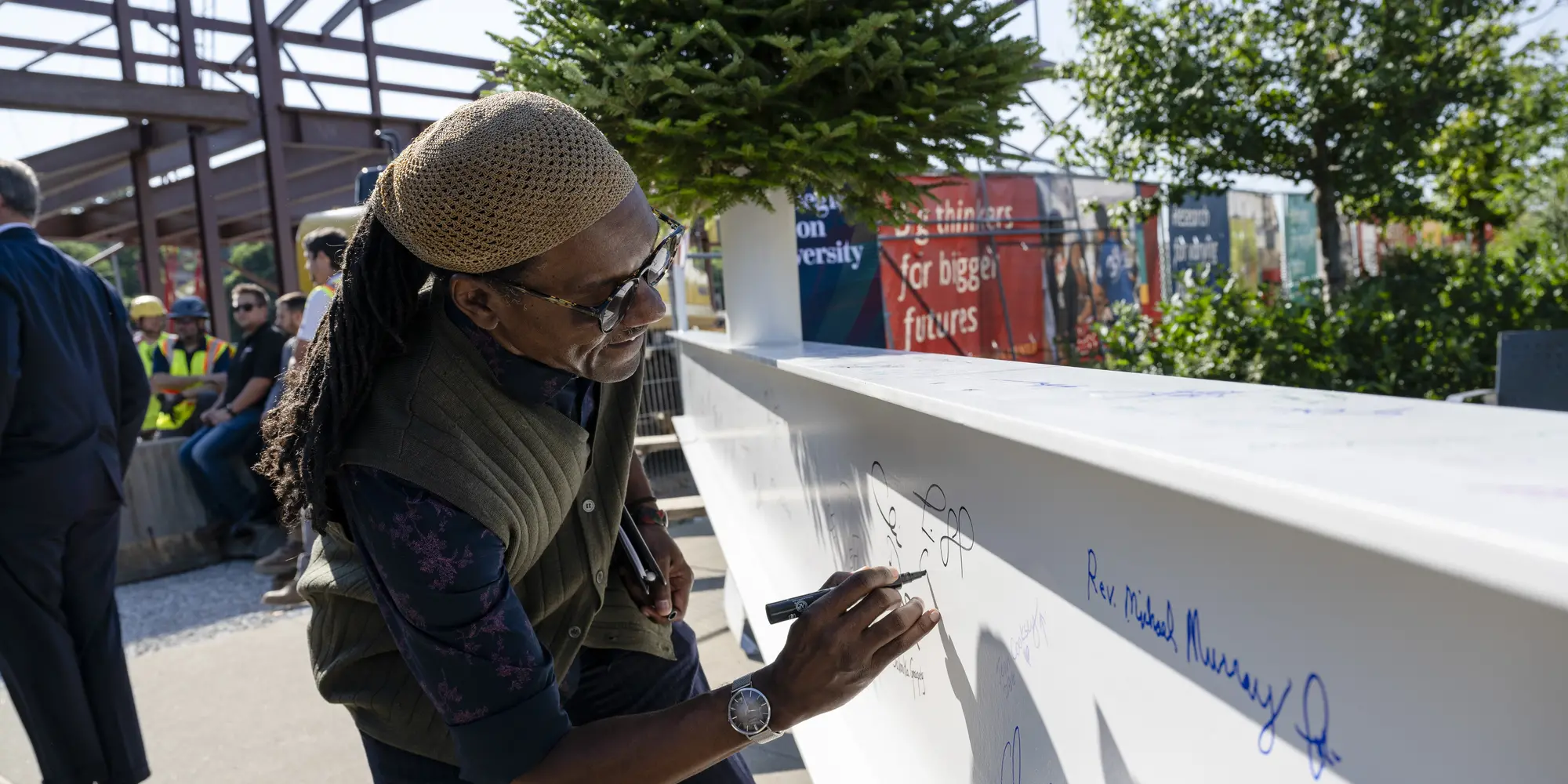 Tim Smith, CEO of Center of Life, signs the beam before it's put into place atop the Robotics Innovation Center..