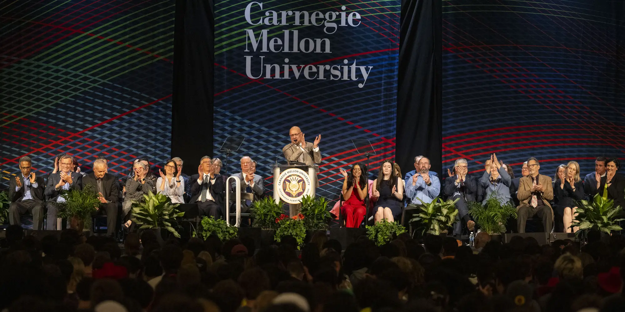 CMU President Farnam Jahanian speaks at a podium.