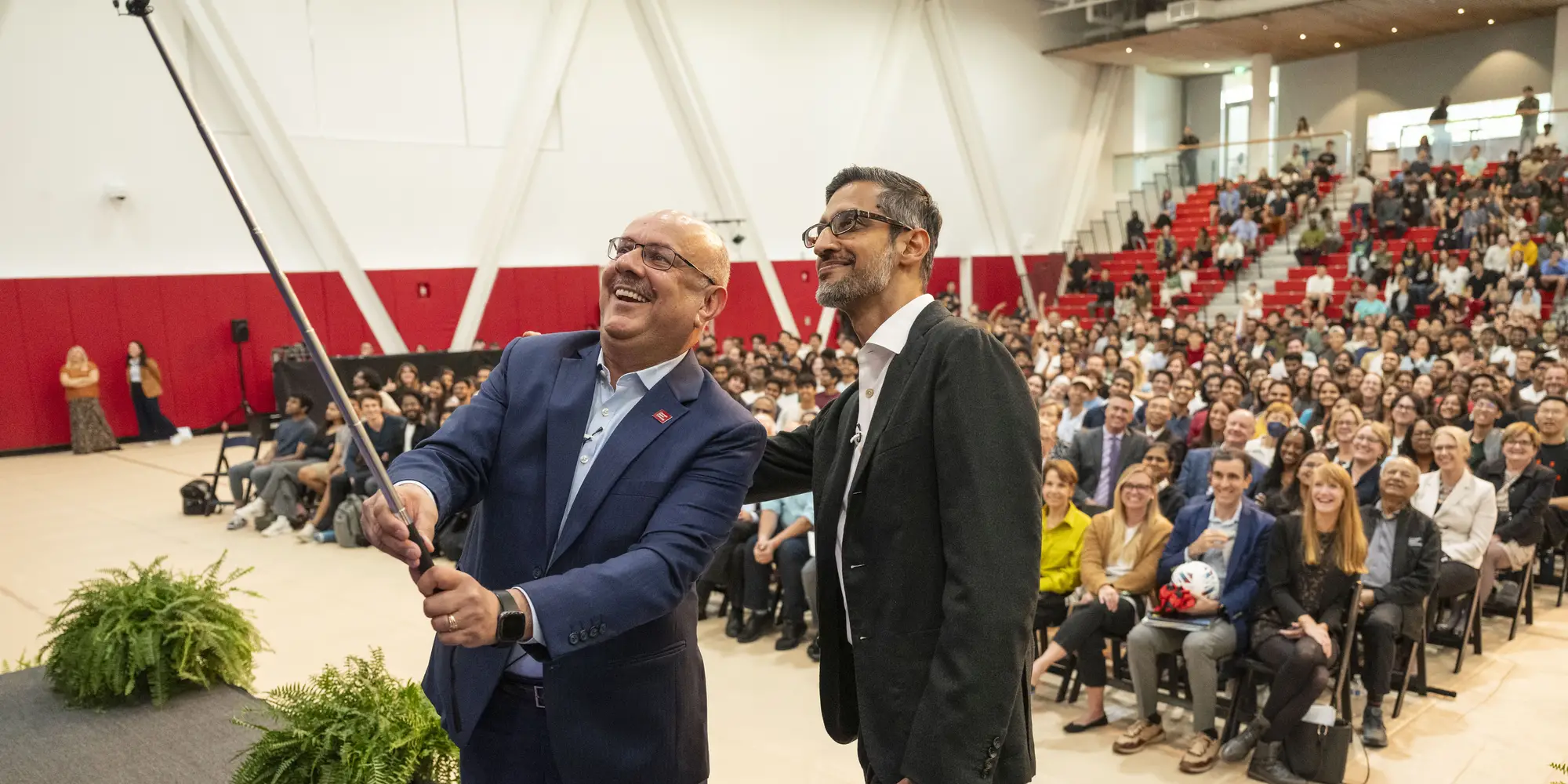 President Farnam Jahanian and Sundar Pichai posing for a selfie with the audience at the President's lecture series.