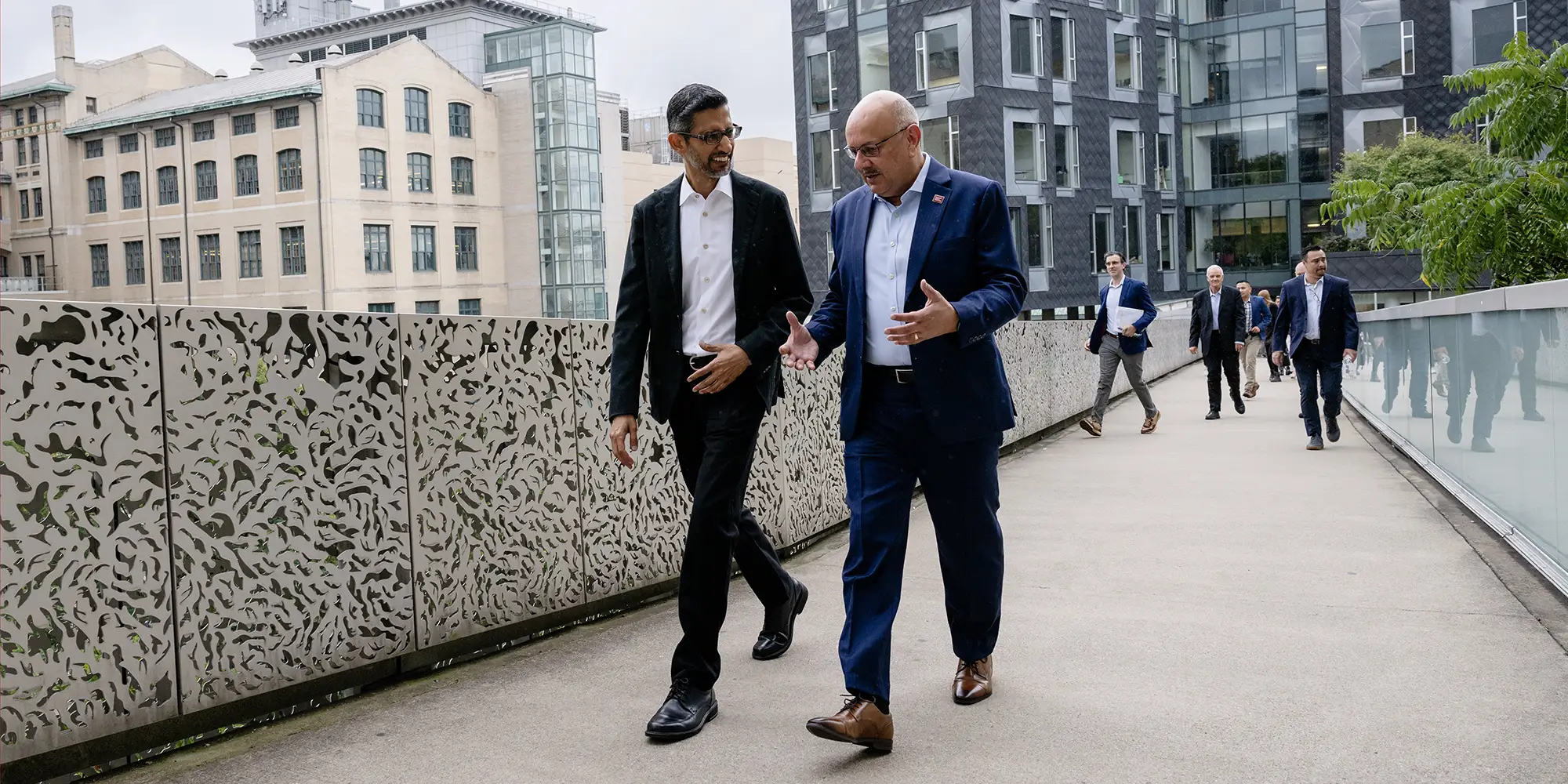 Sundar Pichai walks with Farnam Jahanian on the Pausch Bridge at CMU.